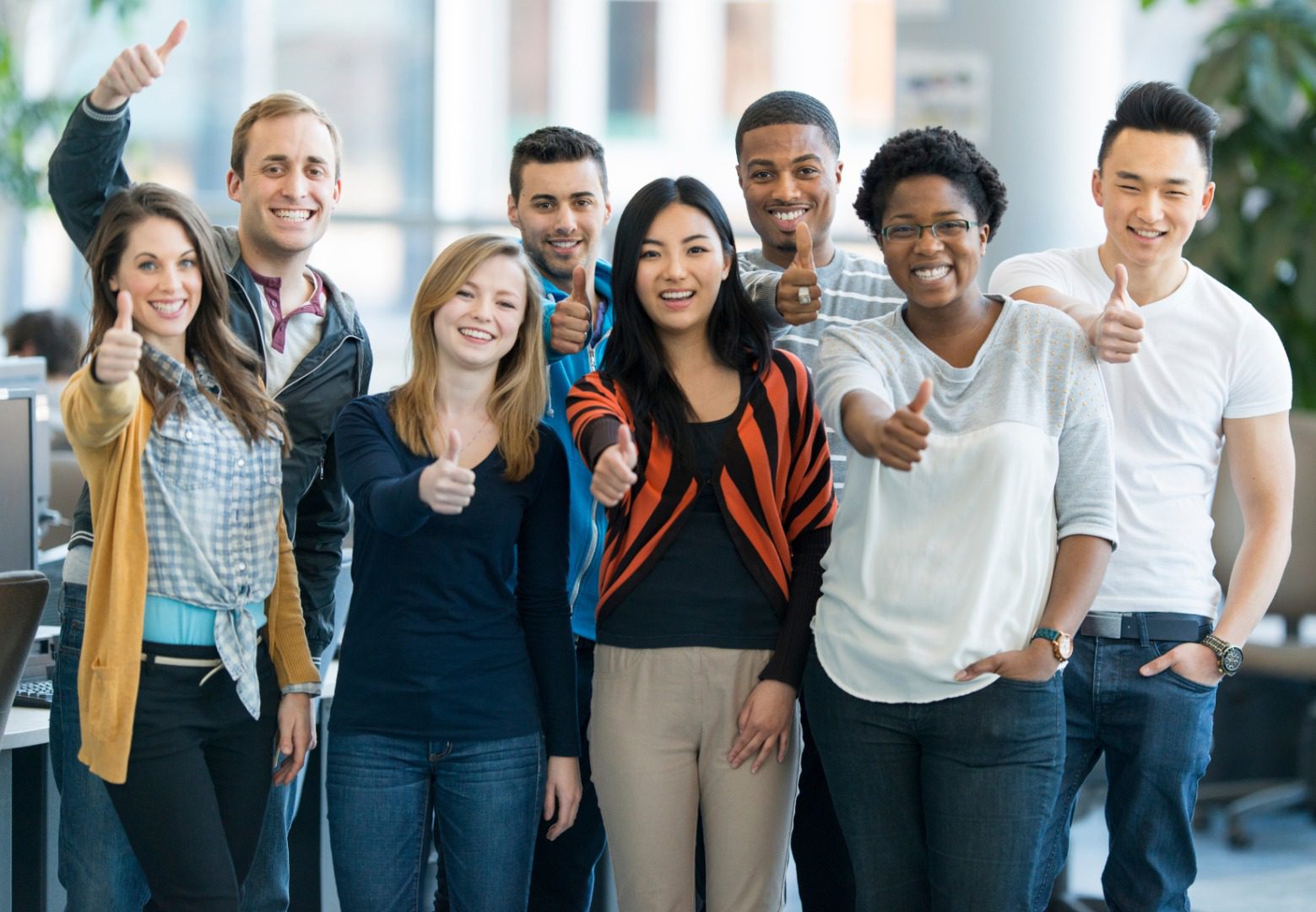 Group of diverse friends giving thumbs up.